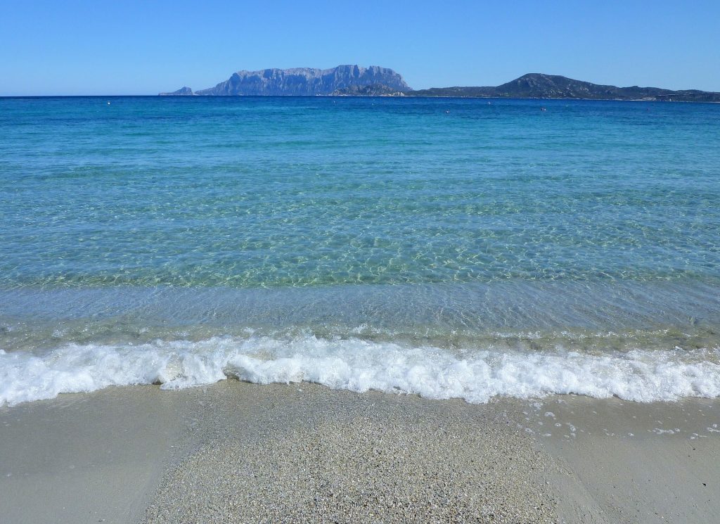 Turismo sostenibile in Sardegna, a confronto con le Azzorre. Spiaggia antistante l'Isola di Tavolara, Sardegna