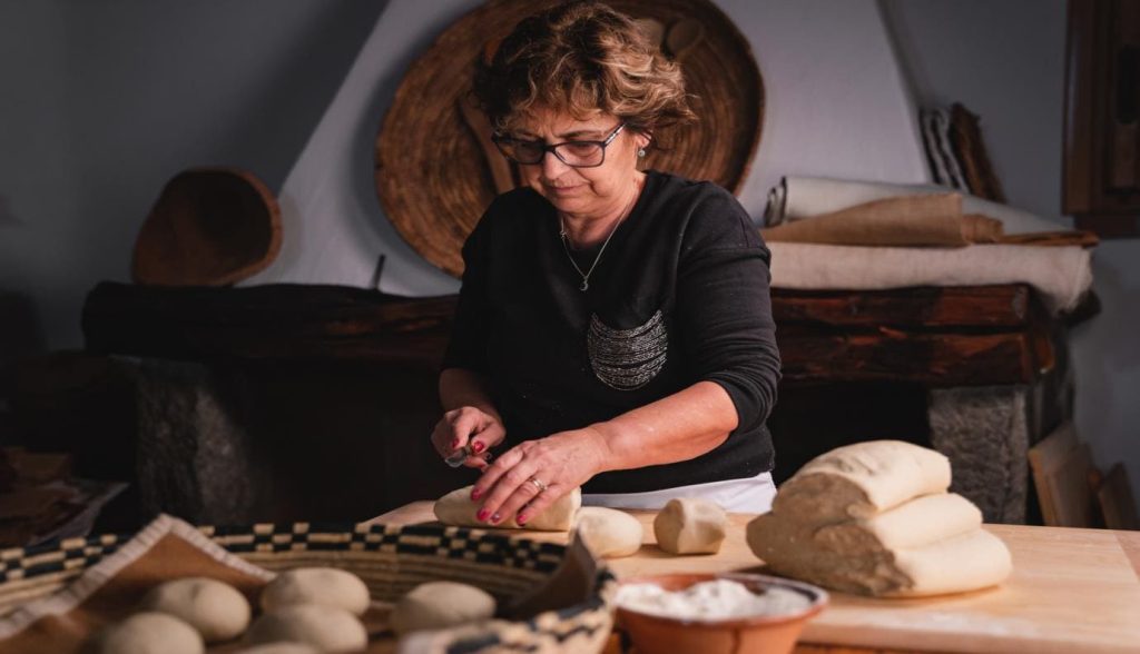 Signora che prepara la pasta in modo tradizionale a Lollove, borgo di turismo sostenibile in Sardegna